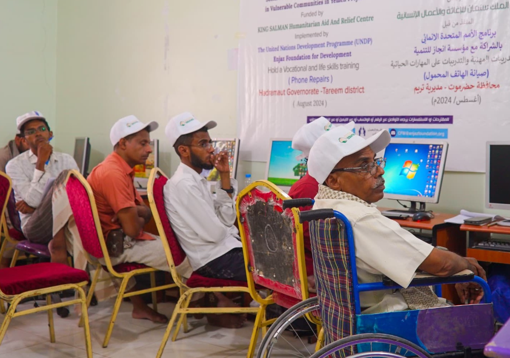 picture of men being given a course and a man with disability is seen with yhem